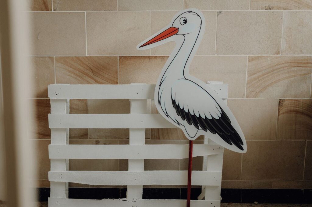 Storchendekoration im Storchennest Eine dekorative Storchfigur vor einer weißen Holzpalette im Eingangsbereich der Kindertagespflege Storchennest, die das freundliche und kindgerechte Ambiente unterstreicht.
