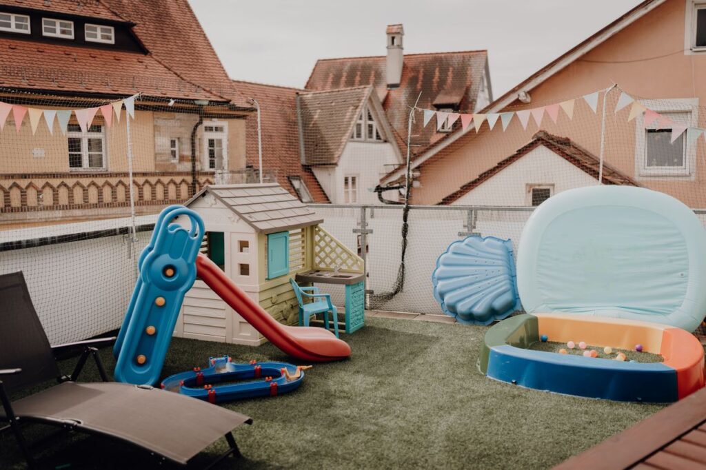 Außenbereich mit Rutsche und Spielhaus im Storchennest Der liebevoll gestaltete Außenbereich der Kindertagespflege Storchennest mit Spielhaus, Rutsche und Planschbecken lädt Kinder zum Spielen und Entdecken ein.